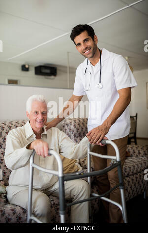 Krankenschwester, die ältere Menschen aufstehen helfen Stockfoto