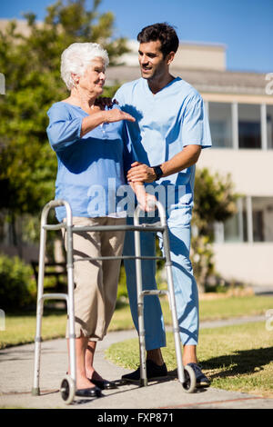 Krankenschwester, schieben die senior Womans Zimmer frame Stockfoto