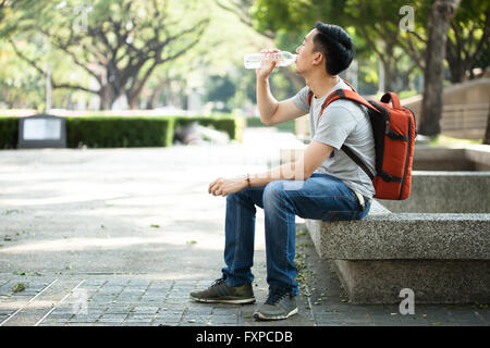 Man Trinkwasser aus der Flasche im Park - Gesundheits-Konzept Stockfoto