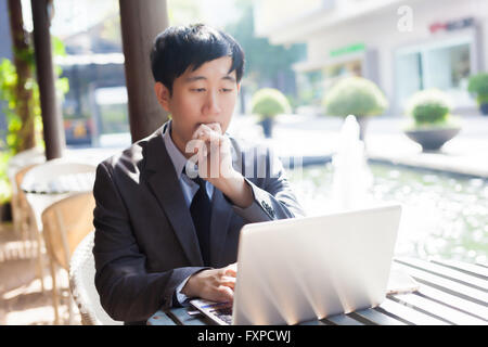 Junge asiatische lässige Geschäftsmann Denken während der Arbeit in outdoor-Szene Stockfoto