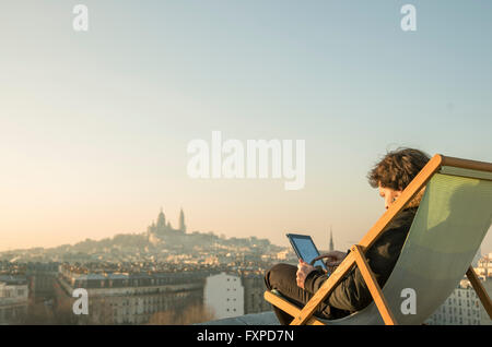 Mann entspannend auf Dachterrasse mit digital-Tablette Stockfoto