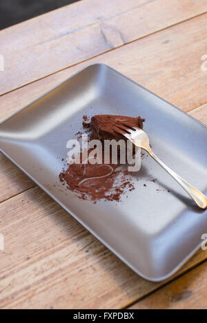 Herz, gezeichnet in Kakaopulver und die Hälfte gegessen Schokoladenkuchen Stockfoto