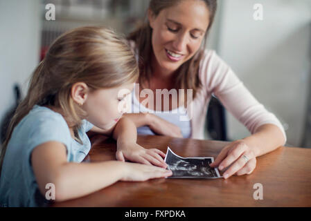 Mutter zeigt Tochter Ultraschall Foto Stockfoto