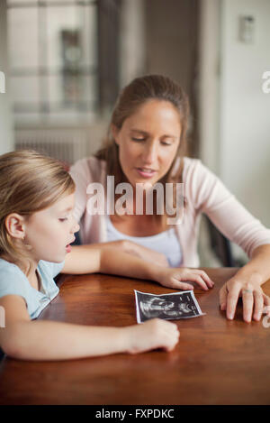 Mutter zeigt Tochter Ultraschall Foto Stockfoto