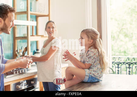 Mädchen im Chat mit Eltern vorbereiten Familienessen in Küche Stockfoto