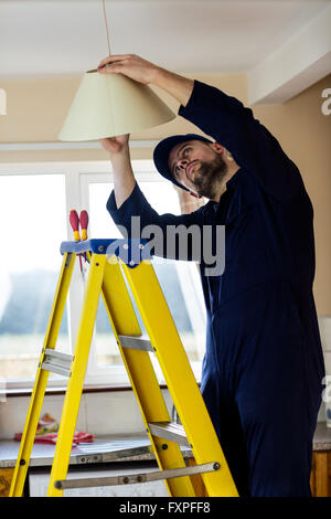Elektriker Reparatur eine Deckenleuchte Stockfoto
