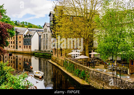 Boote vor Anker auf dem ruhigen Fluss Dart in Totnes zwischen renovierten alten Lagerhäusern auf der einen Seite und grüne Bäume auf der anderen Stockfoto