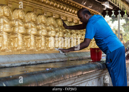 Ein Mann Reinigung die Idole von Lord Buddha erlernte Raja Maha Vihara Tempel in Colombo, Sri Lanka Stockfoto