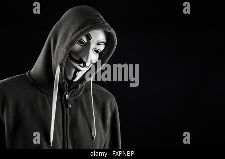 Vermummte Mann mit v for Vendetta Maske auf schwarzem Hintergrund Stockfoto