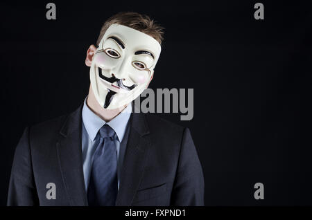Mann im Anzug mit v for Vendetta Maske auf schwarzem Hintergrund Stockfoto