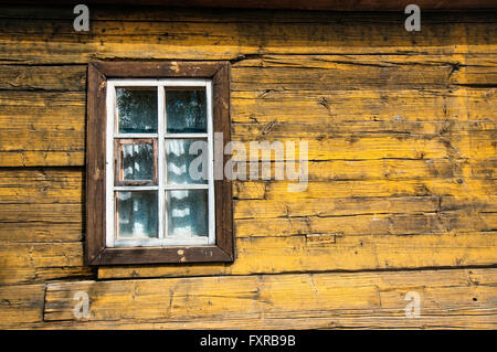 Gelbes Fachwerkhaus Holzwand mit weißen Fenster Stockfoto