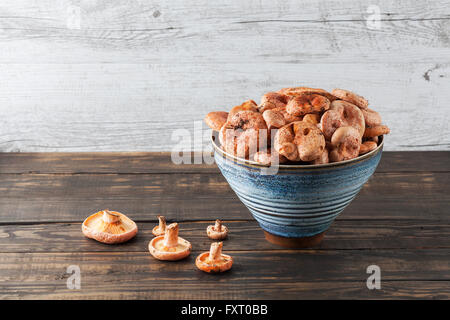 Orange Speisepilze - Safran-Milch-Cap in Keramikschale auf Holztisch mit Textfreiraum Stockfoto