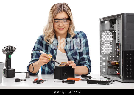 Weibliche PC-Techniker Löten einen Chip von einem Desktop-Computer isoliert auf weißem Hintergrund Stockfoto