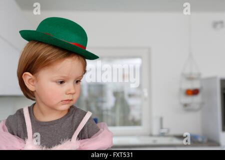 Mädchen gekleidet in Prinzessin Kleid und Bowler Hut wegschauen Stockfoto