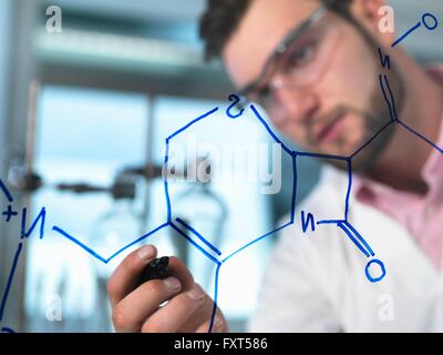 Junge männliche Wissenschaftler illustrieren Antibiotika chemische Formel in pharmazeutischen Forschungslabor Stockfoto