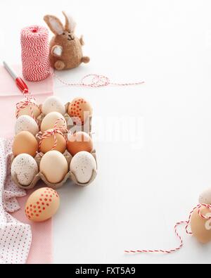 Karton des Hauses verziert Ostereier und Osterhasen auf weißen Tisch Stockfoto