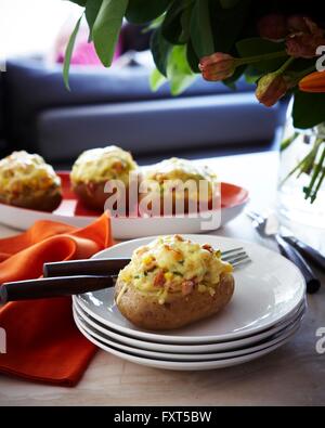 Platten mit gefüllte gebackene Kartoffeln auf Tisch Stockfoto