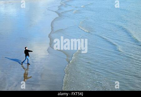 Hohen Winkel Seitenansicht des reifen Mannes am Strand Steinwürfe in Ozean Stockfoto