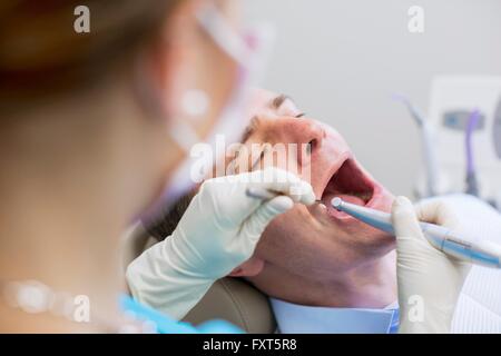 Über die Schulter-Blick von Zahnarzt dental Prüfung auf reifer Mann Stockfoto