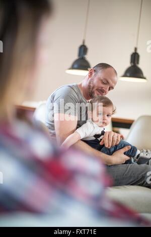 Blick über die Schulter des jungen auf Väter Schoß Stockfoto