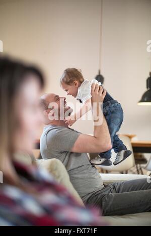 Vater hob Baby junge Gesicht lächelnd Stockfoto