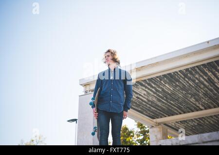 Portrait von junge männliche urban Skater Skateboard halten Stockfoto