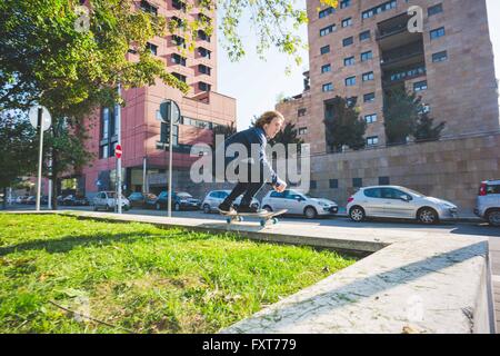 Junge männliche Skater Skateboard an städtischen Wand Stockfoto