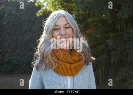 Porträt der Frau mit langen grauen Haaren, Blick auf die Kamera zu Lächeln Stockfoto