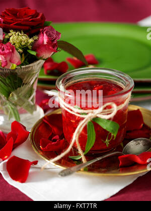 Glas hausgemachte Johannisbeer Marmelade und Rosenblätter auf dem Tisch Stockfoto