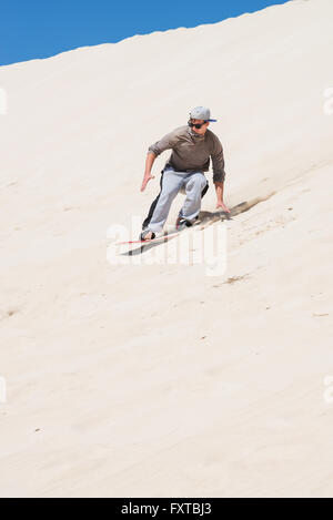 Sandboarding auf Sanddünen in Little Sahara, Kangaroo Island, South Australia.Focus auf den Mann Stockfoto