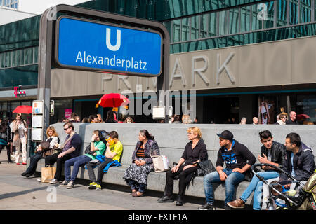 Leute sitzen neben Eingang Alexanderplatz U Bahn Station in Berlin Deutschland Stockfoto