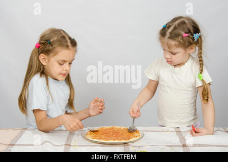 Zwei kleine Schwestern konzentriert Abstrich Sauce Basis pizza Stockfoto