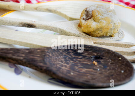 Schokolade Windbeutel mit Puderzucker Sugare auf Holzlöffel Stockfoto