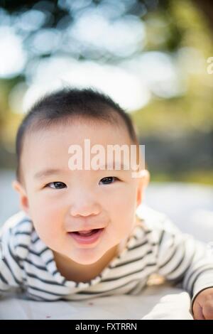 Baby Junge liegend auf Bauch im freien Stockfoto