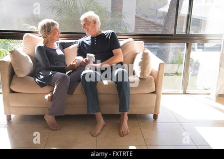 Älteres Paar, entspannt auf dem Sofa, Gesicht sitzen, Lächeln Stockfoto