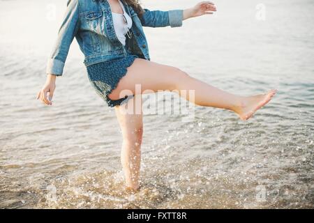 Niedrigen Bereich Seitenansicht der Frau auf einem Bein, Paddeln im Ozean Stockfoto