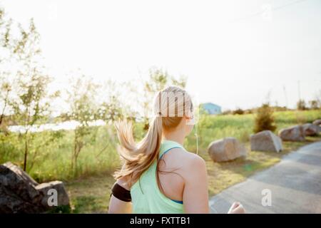 Kopf und Schultern der Trägerin Aktivität Tracker jogging am Weg Stockfoto