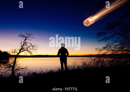 Silhouette der Erwachsenen beobachten Meteor fallen im Nachthimmel Stockfoto