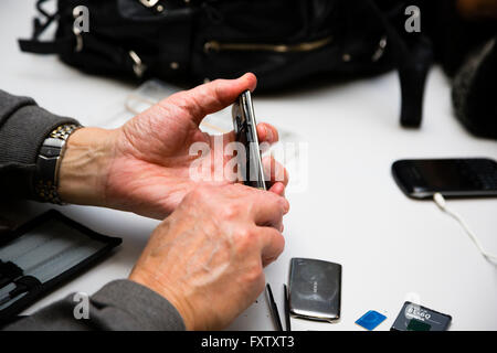 Hackney, London, UK. Volunteer bei Neustart Partei helfen ein Client eine Batterie in einem Smartphone ersetzen. Stockfoto