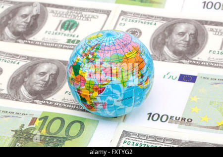 Eine Kugel auf hundert Dollar und Euro-Noten Stockfoto