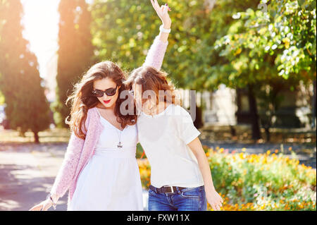 Zwei junge glückliche Frauen wandern in die Sommer-Stadt Stockfoto