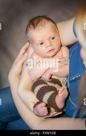 junge Mutter ihr Baby Sohn in Armen halten Stockfoto