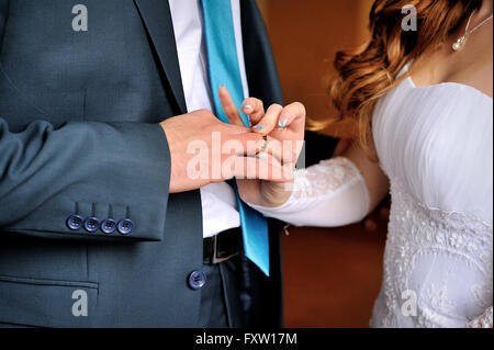 Braut trägt Bräutigam gold Ring auf Hochzeits-Zeremonie Stockfoto