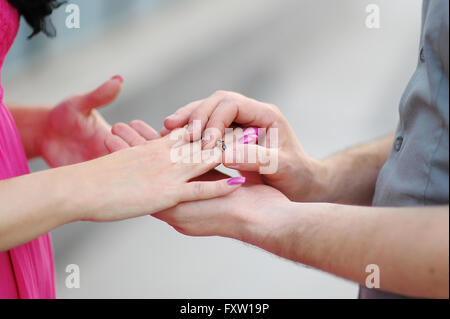 Bräutigam steckt Ring auf die Braut. Close-up Stockfoto