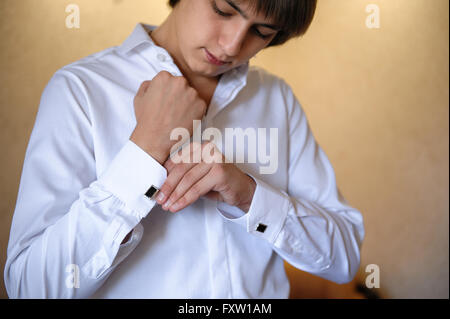 Bräutigam trägt Manschettenknöpfe auf weißem Hemd Stockfoto