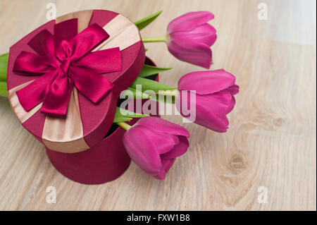 Drei Tulpen und rotes Kästchen Geschenk in Form von Herzen Stockfoto