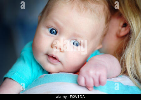 Schöne junge Mutter hält einen kleinen Sohn Stockfoto