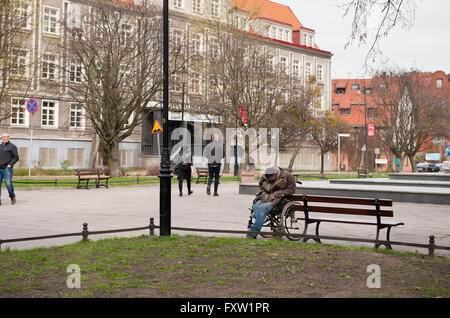 Buckliger ungültig Obdachloser am Rollstuhl, schlafen draußen im Park, kalten Frühlingstag in Danzig, Westpommern Stockfoto