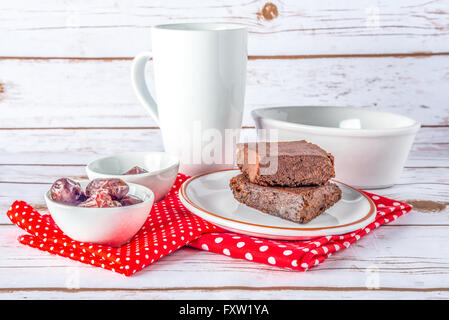 Gesunde glutenfreie Paleo-Stil-Brownies mit Süßkartoffel, Termine und Mandel-Mehl auf einem weißen Teller mit Tasse auf Hintergrund gemacht Stockfoto