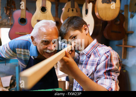 Kleiner Familienbetrieb und Traditionen: alten Opa mit Enkel im laute Hersteller Shop. Die senior Handwerker lehrt dem jungen wie Stockfoto